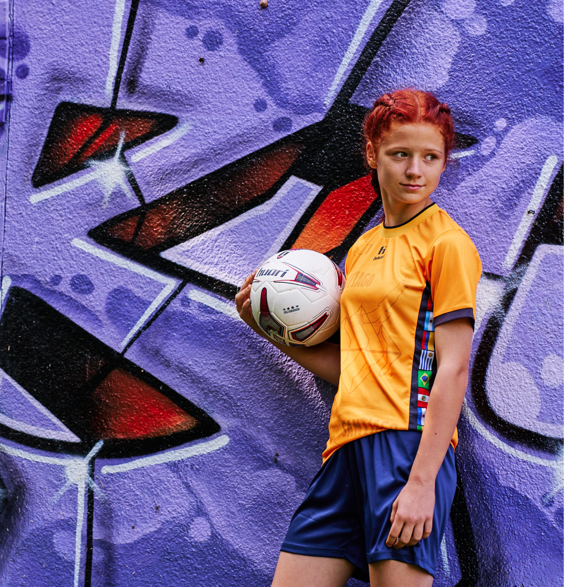 dziewczyna w piłkarskim stroju marki Huari trzymająca piłkę